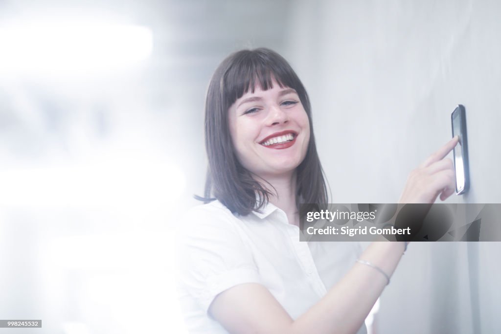 Woman using wall mounted touch screen control panel