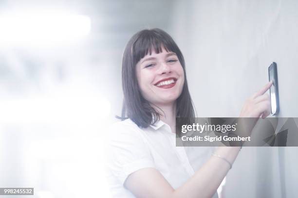 woman using wall mounted touch screen control panel - sigrid gombert 個照片及圖片檔