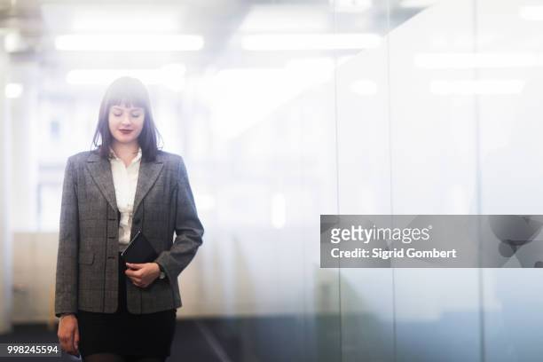 businesswoman in office holding digital tablet - sigrid gombert imagens e fotografias de stock