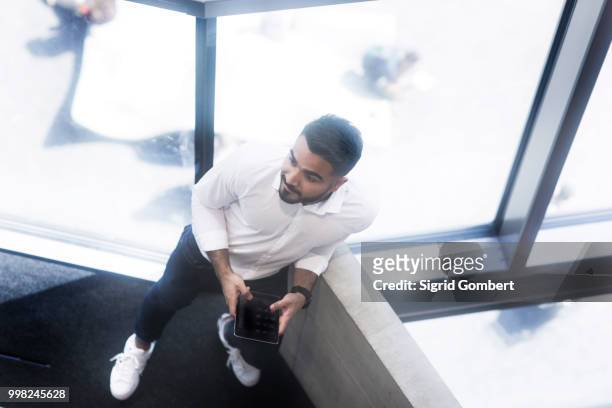 young man using digital tablet in office - sigrid gombert foto e immagini stock