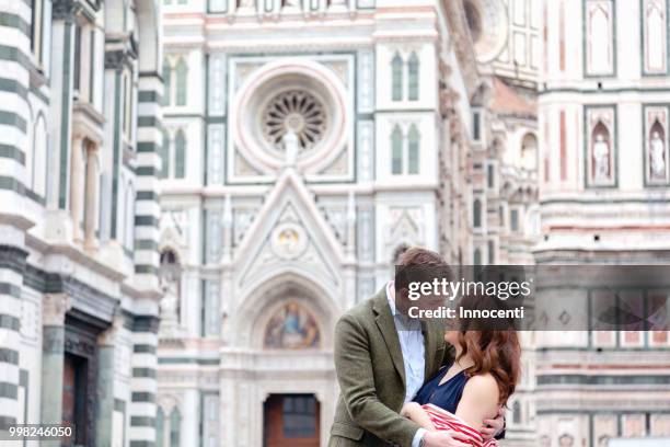 young couple hugging, santa maria del fiore, florence, toscana, italy - mimosa fiore fotografías e imágenes de stock