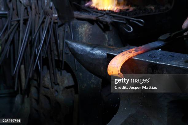 red hot metal on anvil in blacksmiths shop - anvil stock pictures, royalty-free photos & images