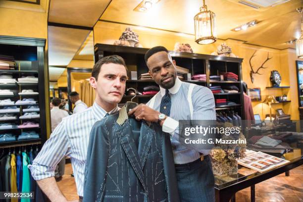 tailor holding bespoke suit jacket against customer in tailors shop - customer appreciation stock pictures, royalty-free photos & images