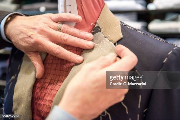 tailor preparing bespoke suit jacket on tailors dummy, close up of hands - bespoke stock pictures, royalty-free photos & images