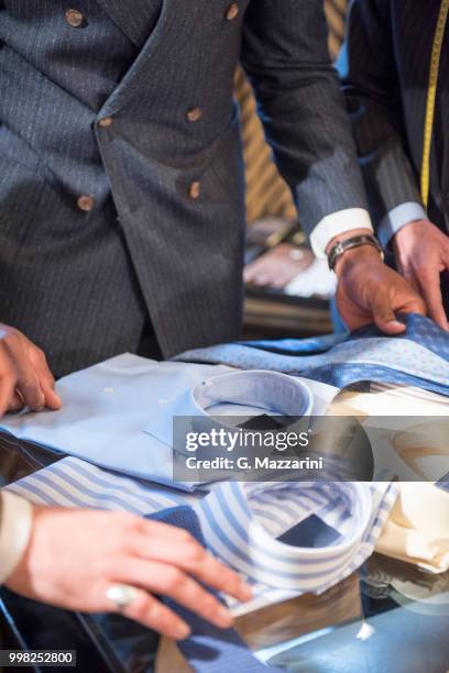 tailors and customer looking at shirts in tailors shop, detail - custom tailored suit - fotografias e filmes do acervo