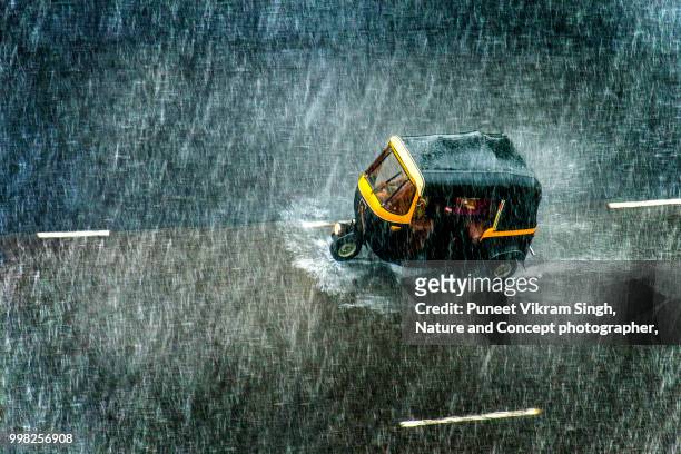 an auto rickshaw on the mumbai road during a heavy rainfall - torrential rain stockfoto's en -beelden