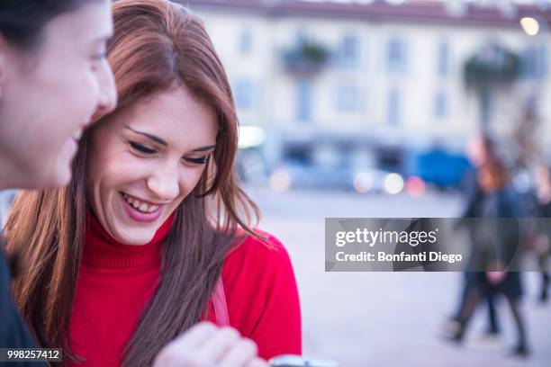 young women sharing joke, milan, lombardy, italy - diego rojas fotografías e imágenes de stock