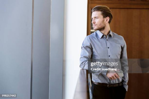 businessman daydreaming in corridor - leaning on elbows stock pictures, royalty-free photos & images