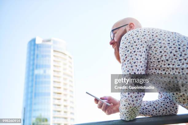 man holding smartphone in business area - gpointstudio imagens e fotografias de stock