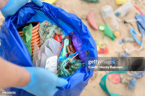 man holding bag full of plastic pollution collected on beach, north east england, uk - east beach stock pictures, royalty-free photos & images