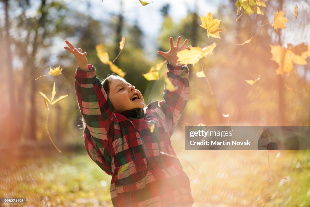 Girl enjoy falling leaves