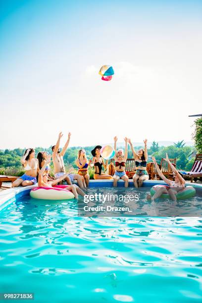 amigos jugando con pelota de playa en la piscina - fiesta de piscina fotografías e imágenes de stock