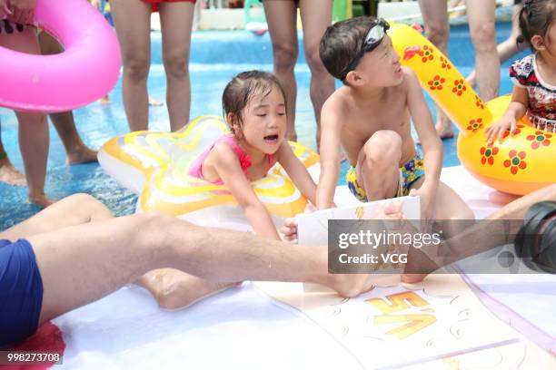 People compete in a toe wrestling competition at a water park on July 11, 2018 in Chongqing, China.