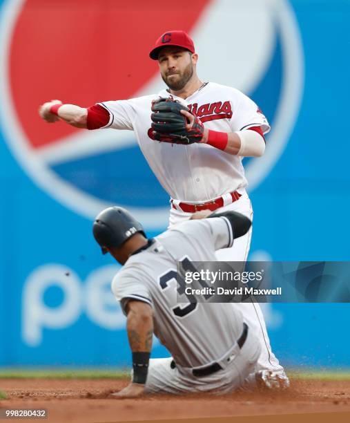 Aaron Hicks of the New York Yankees is out at second as Jason Kipnis of the Cleveland Indians throws to first to retire Giancarlo Stanton on a double...