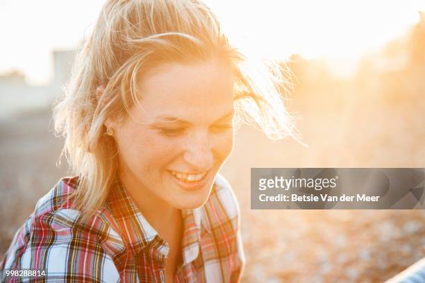portrait of blond woman on beach, back lit evening sunlight. - meer photos et images de collection