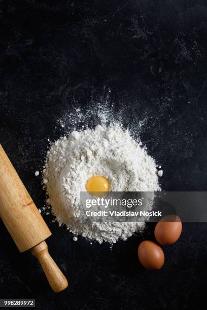 flour, eggs and rolling pin on dark background - rolling pin photos et images de collection