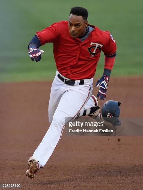 Jorge Polanco of the Minnesota Twins looses his helmet as he runs the base path between second and third base after hitting an RBI triple against the...