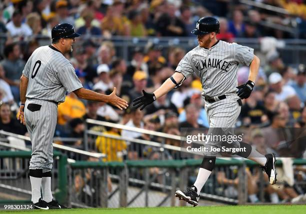 Brandon Woodruff celebrates his solo home run with Ed Sedar of the Milwaukee Brewers during the sixth inning against the Pittsburgh Pirates at PNC...