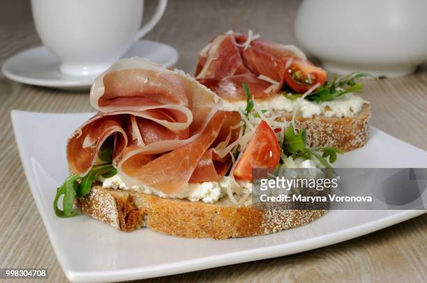 sandwich of jamon with ricotta, arugula and cheese - jamon stockfoto's en -beelden