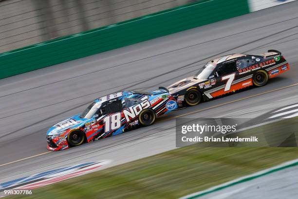 Kyle Busch, driver of the NOS Energy Drink Toyota, leads Justin Allgaier, driver of the Dale Jr's Whisky River Chevrolet, during the NASCAR Xfinity...