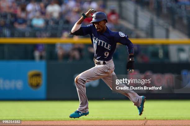 Dee Gordon of the Seattle Mariners advances to third base after the ball got past the first baseman on a pickoff attempt in the first inning of a...