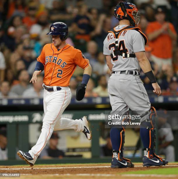 Alex Bregman of the Houston Astros scsores in the third inning in front of James McCann of the Detroit Tigers at Minute Maid Park on July 13, 2018 in...