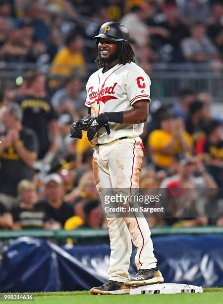 Josh Bell of the Pittsburgh Pirates celebrates his RBI triple during the eighth inning against the Milwaukee Brewers at PNC Park on July 13, 2018 in...