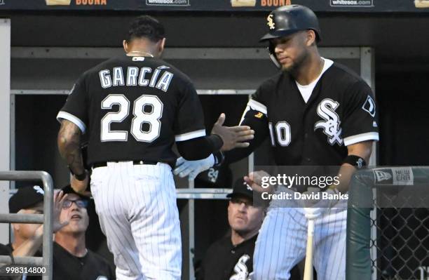 Leury Garcia of the Chicago White Sox is greeted by Yoan Moncada after scoring against the Kansas City Royals during the third inning on July 13,...