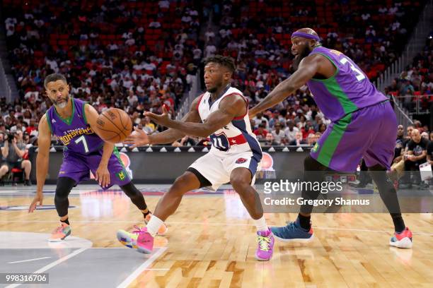 Nate Robinson of Tri-State passes the ball between Mahmoud Abdul-Rauf and Reggie Evans of the 3 Headed Monsters during BIG3 - Week Four at Little...