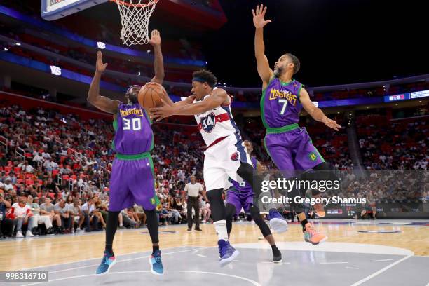 David Hawkins of Tri-State passes the ball between Reggie Evans and Mahmoud Abdul-Rauf of the 3 Headed Monsters during BIG3 - Week Four at Little...