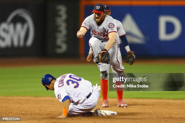 Michael Conforto of the New York Mets is forced out at second base as Daniel Murphy of the Washington Nationals leaps to avoid the slide at Citi...