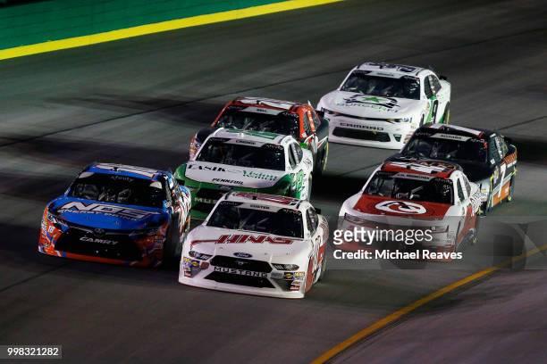Cole Custer, driver of the Haas Automation Ford, and Kyle Busch, driver of the NOS Energy Drink Toyota, lead a pack of cars during the NASCAR Xfinity...