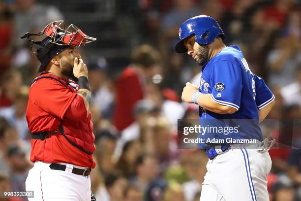 Sandy Leon of the Boston Red Sox looks on as Kendrys Morales of the Toronto Blue Jays crosses home plate after scoring in the eighth inning of a game...
