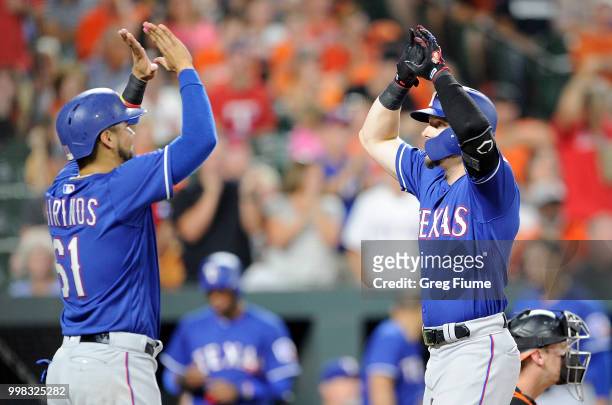 Ryan Rua of the Texas Rangers celebrates with Robinson Chirinos after hitting a three-run home run in the seventh inning against the Baltimore...