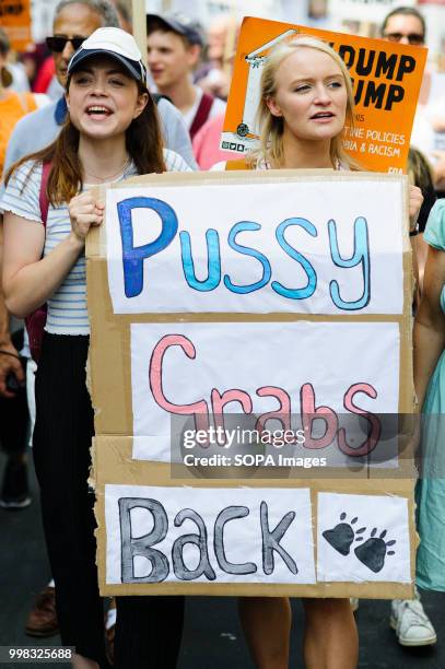 Women are seen holding a poster during the protest against US President Donald Trumps visit to the UK on the second day of the president's stay in...