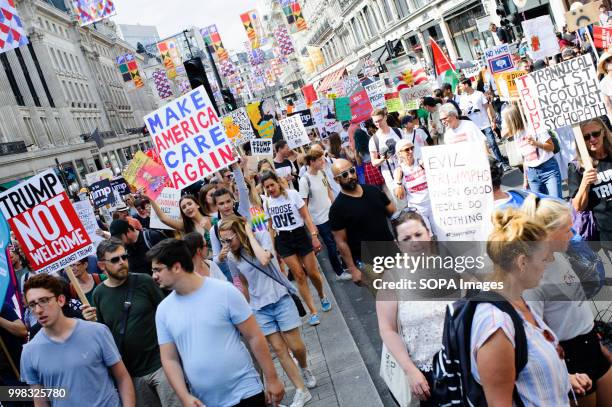 Demonstrators are seen in huge numbers holding posters during the protest against US President Donald Trumps visit to the UK on the second day of the...