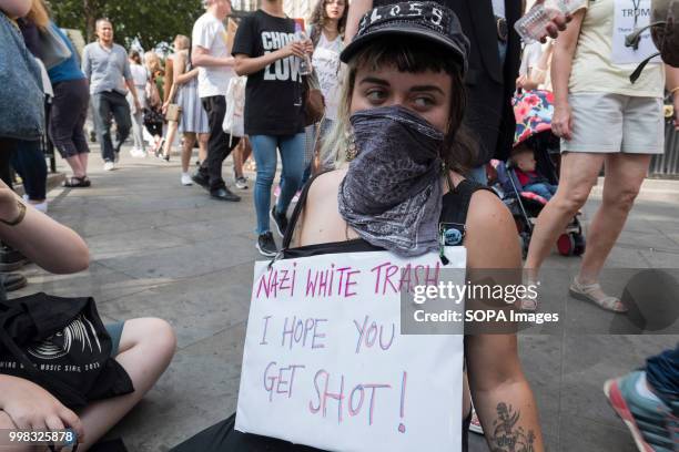 Woman is seen wearing a sign saying Nazi white trash i hope you get shot during the protest against US President Donald Trumps visit to the UK on the...