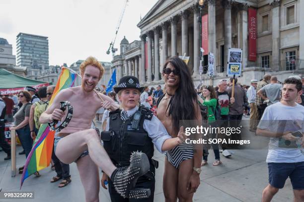 Two homosexual men pose for a picture with a police officer during the demonstration against US President Donald Trumps visit to the UK on the second...