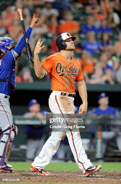 Chris Davis of the Baltimore Orioles tosses his bat after popping out to end the eighth inning against the Texas Rangers at Oriole Park at Camden...