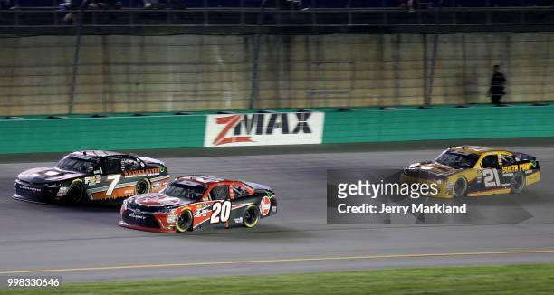 Justin Allgaier, driver of the Dale Jr's Whisky River Chevrolet, leads Christopher Bell, driver of the Rheem Toyota, and Daniel Hemric, driver of the...