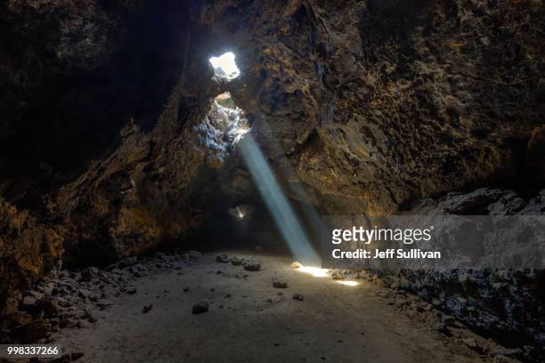 light rays in a lava tube - lava tube stock pictures, royalty-free photos & images