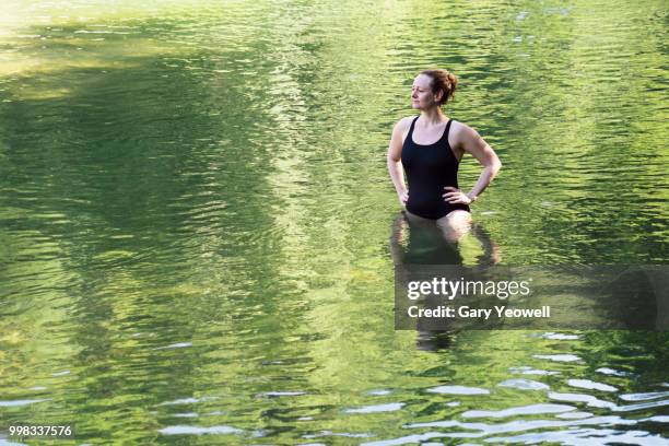 woman standing in a secluded lake - yeowell imagens e fotografias de stock
