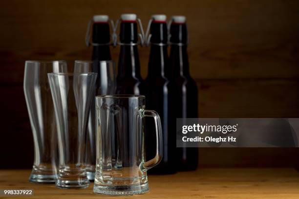 beer glasses and beer bottles on a wooden background - champagner gläser mit flasche unscharfer hintergrund stock-fotos und bilder