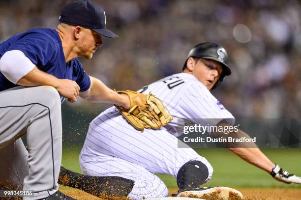 Kyle Seager of the Seattle Mariners applies a tag on DJ LeMahieu of the Colorado Rockies for an out at third base on a fielders choice in the sixth...