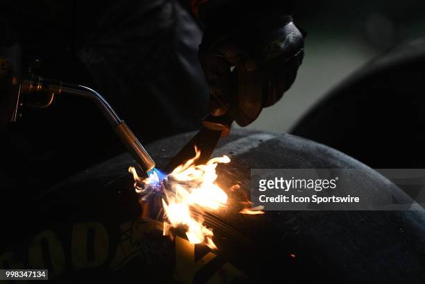 Tire specialist burns some tread off a used tire during the NASCAR Xfinity Series Alsco 300 on July 13th at Kentucky Speedway in Sparta, Kentucky.