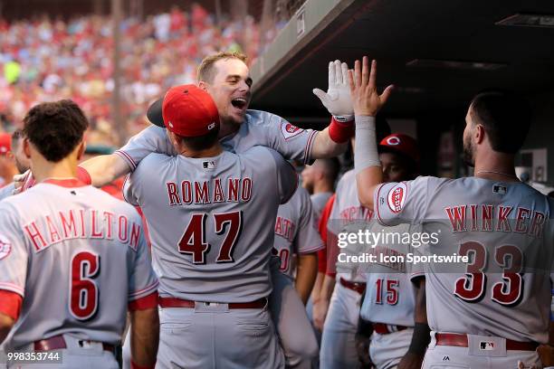 Cincinnati Reds second baseman Scooter Gennett is lifted by teammate starting pitcher Sal Romano as he is congratulated after hitting a solo home run...