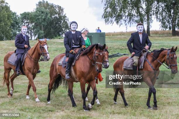 People riding horses wearing Guy Fawkes masks are seen in Grunwald, Poland on 13 July 2018 Battle of Grunwald reenactment participants take part in...