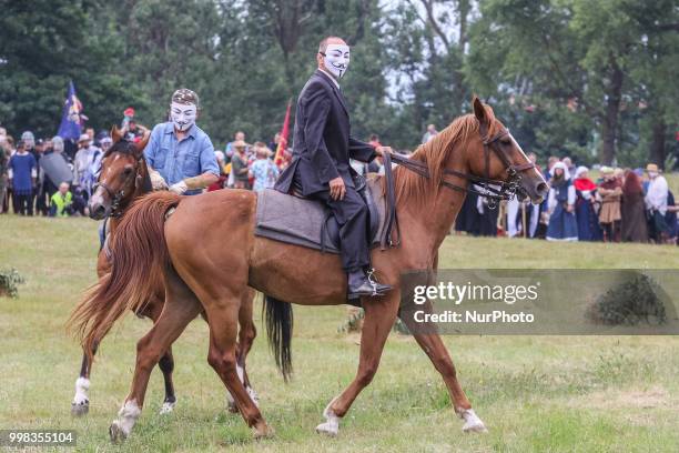 Man riding a horse wearing Guy Fawkes mask is seen in Grunwald, Poland on 13 July 2018 Battle of Grunwald reenactment participants take part in the...