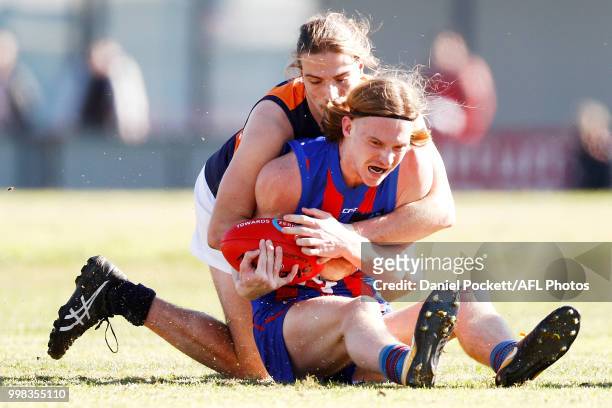 Noah Anderson of the Chargers is tackled by Lucas Cavallaro of the Cannons during the round 12 TAC Cup match between Oakleigh and Calder at Warrawee...