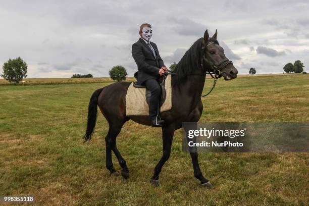 Man riding a horse wearing Guy Fawkes mask is seen in Grunwald, Poland on 13 July 2018 Battle of Grunwald reenactment participants take part in the...